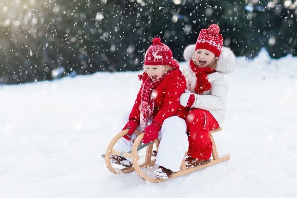 Children play outdoors in snow.