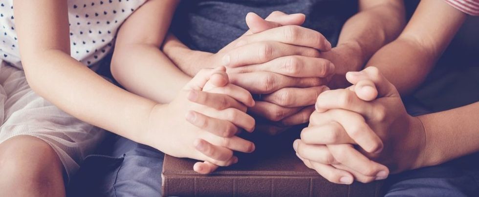 Children praying with parent