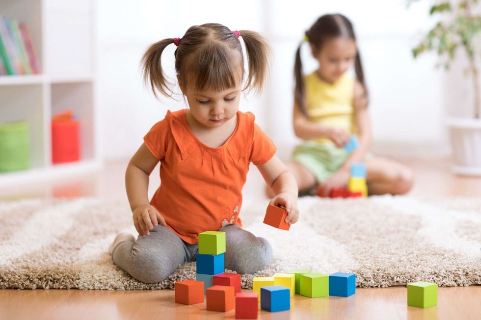 Children toddlers girls play toys at home.