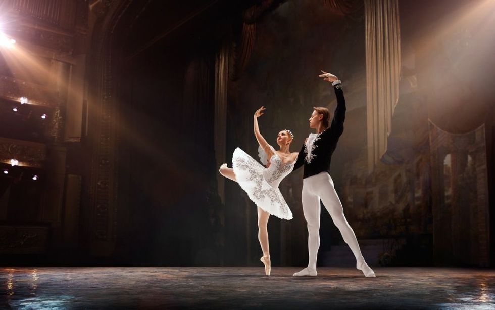Classical ballet performed by a couple of ballet dancers on the stage of the opera house.