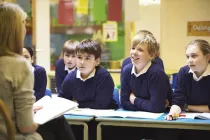 Classroom of kids looking at the teacher while learning maths.