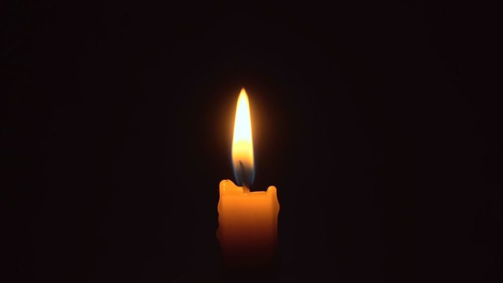 Close-up of lighting a candle with a dark background