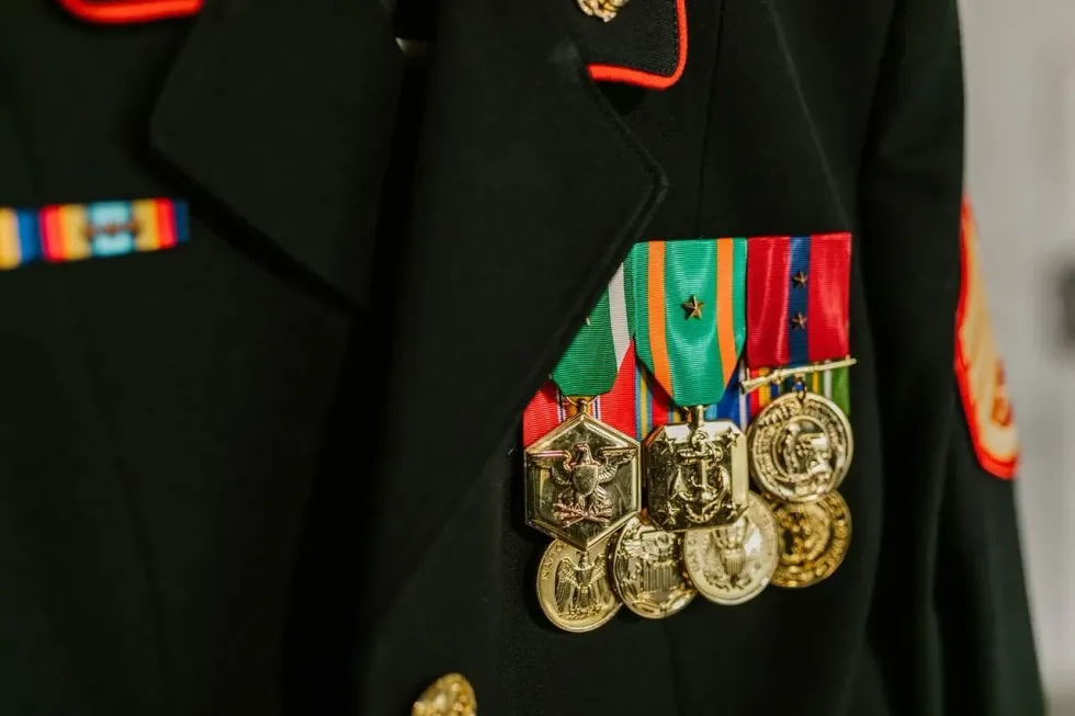 CLose up photo of a navy uniform with gold medals