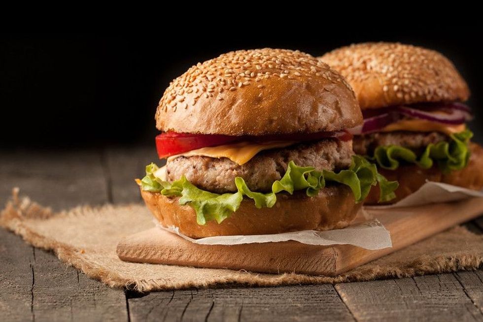 Close-up photo of home made hamburger with beef, onion, tomato, lettuce, cheese and spices.