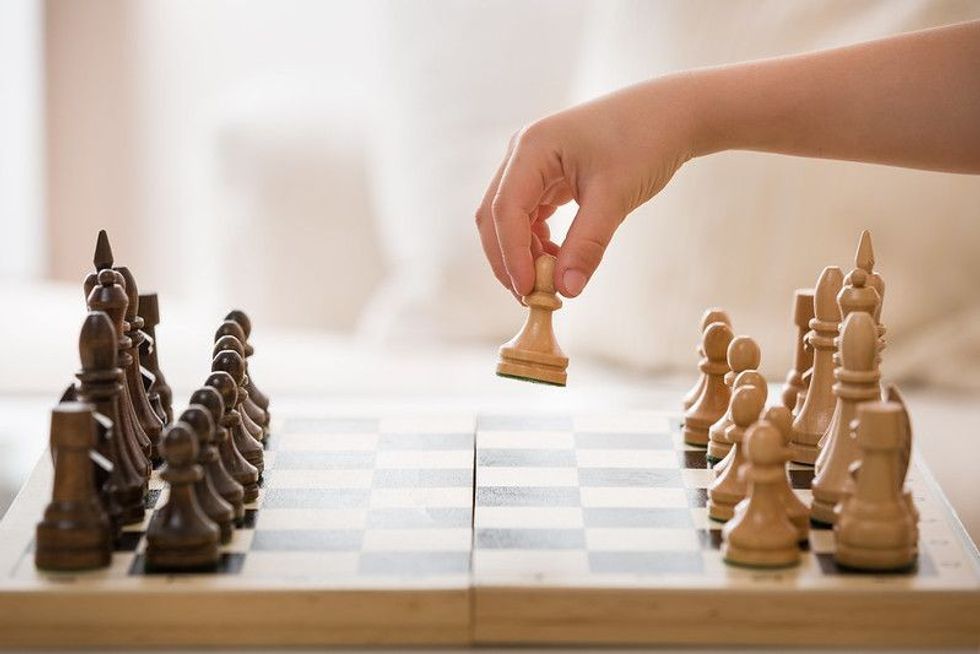 Closeup of a hand and a chess game