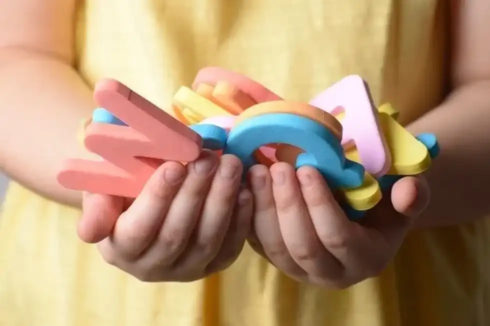 Collection of spongy alphabet letters in little girl's hands