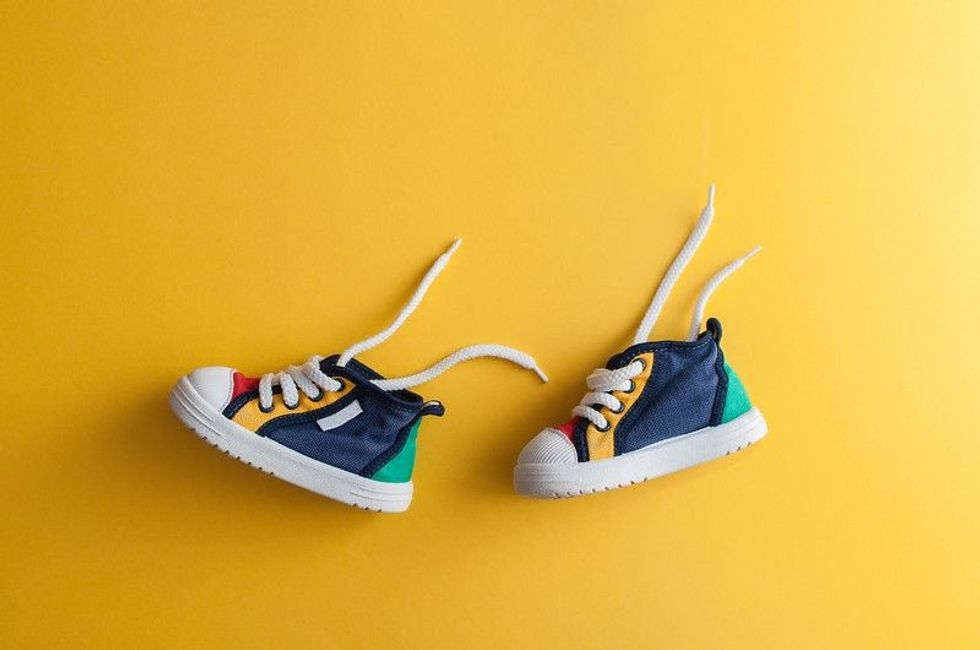 Colorful baby shoes on a yellow background