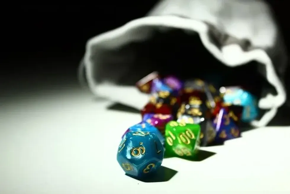 colorful d20 dice falling from the grey pouch