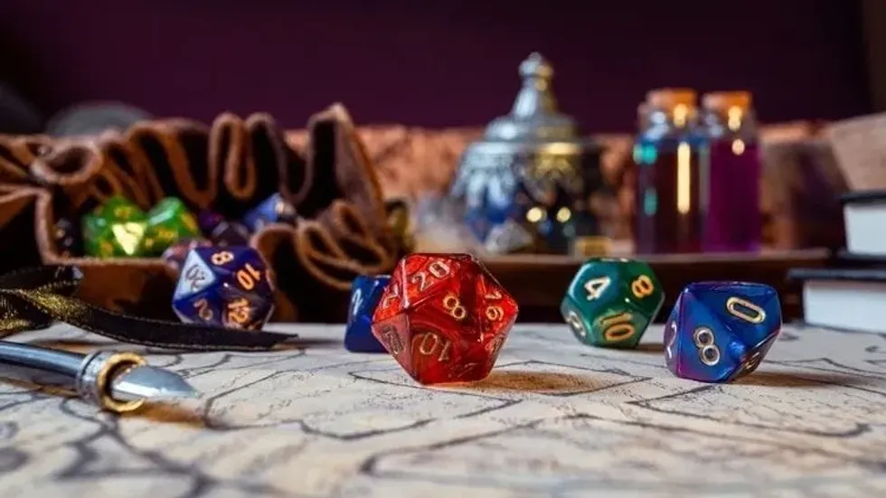 colorful d20 dice on strategy paper and leather pouch