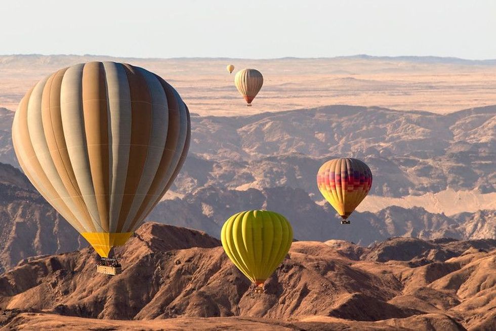 Colorful hot air balloons flying over the moon valley mountain.