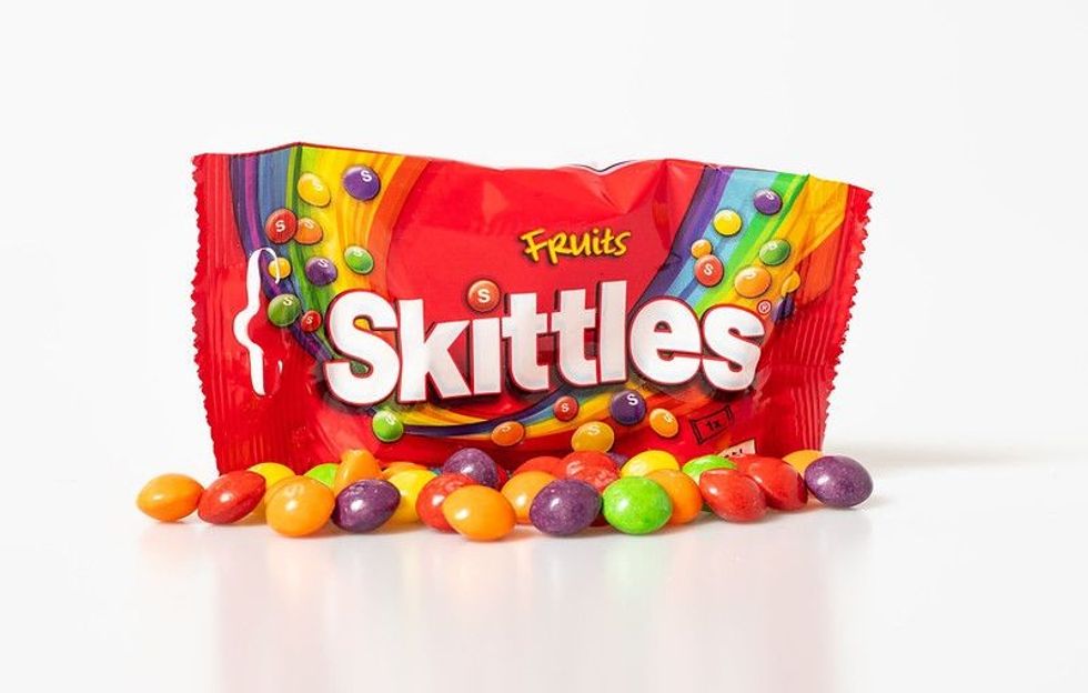 Colorful skittles spread in front of Skittles packet