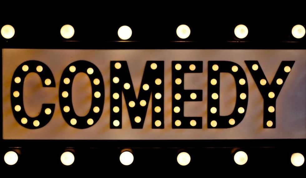 Comedy sign lit up in lights on a retro sign