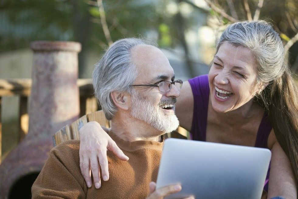Couple laughing while sharing a tablet