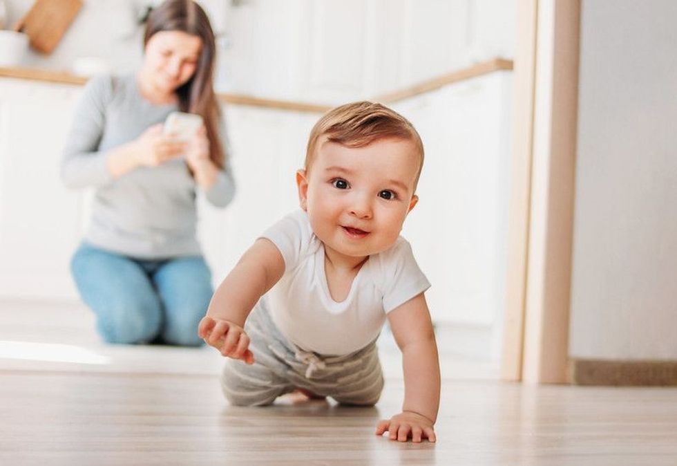Cute baby boy crawling on the floor.
