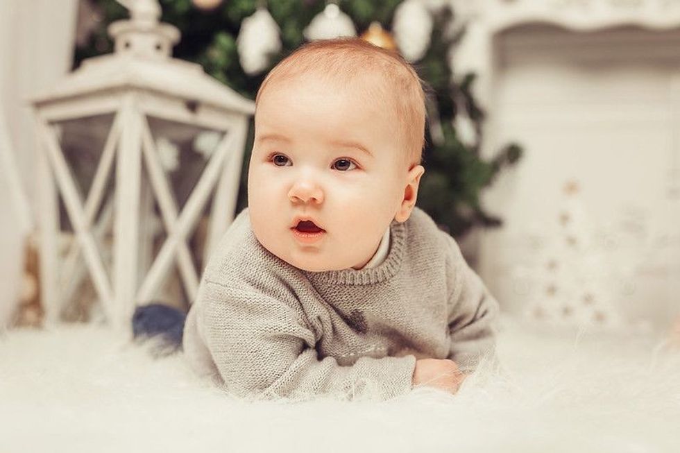 Cute baby sitting on fluffy couch