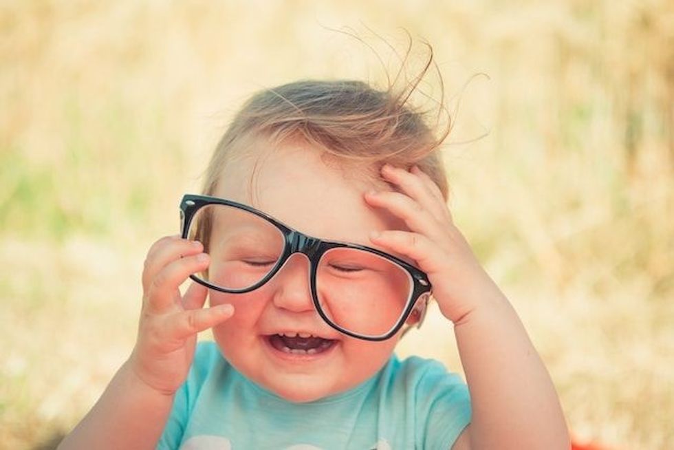 Cute baby wearing crooked glasses