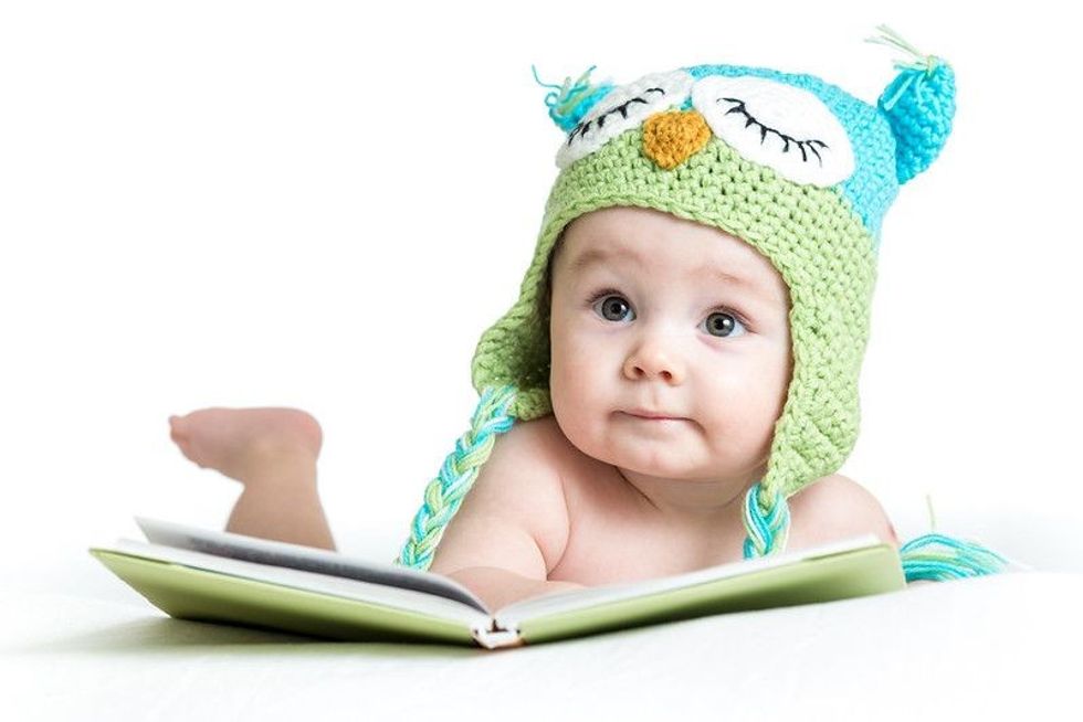 Cute baby with book in white background.