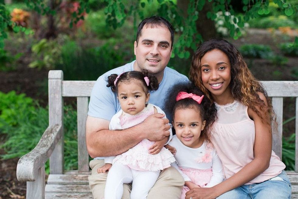 Cute family sitting together in park.