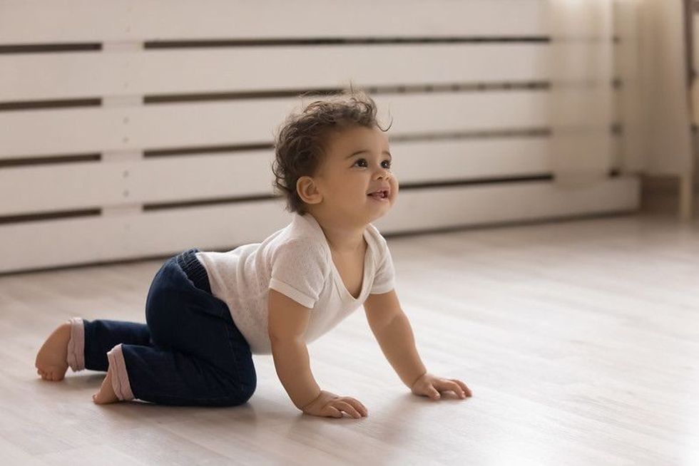 Cute little baby crawling on the floor.