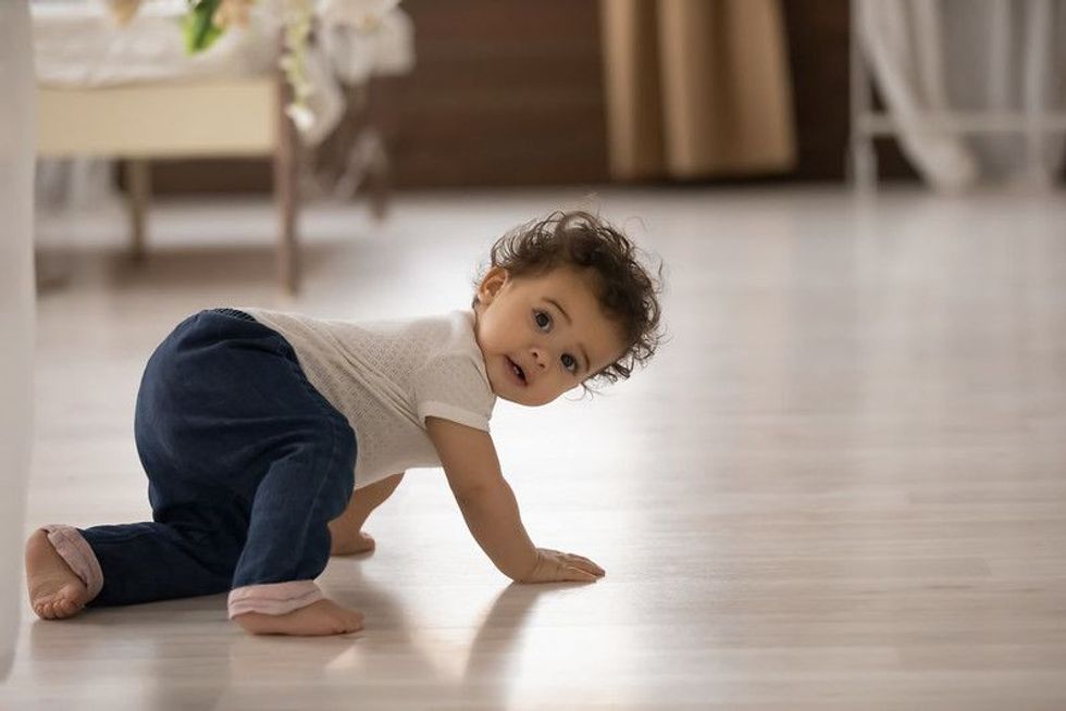Cute little ethnic baby crawling indoor
