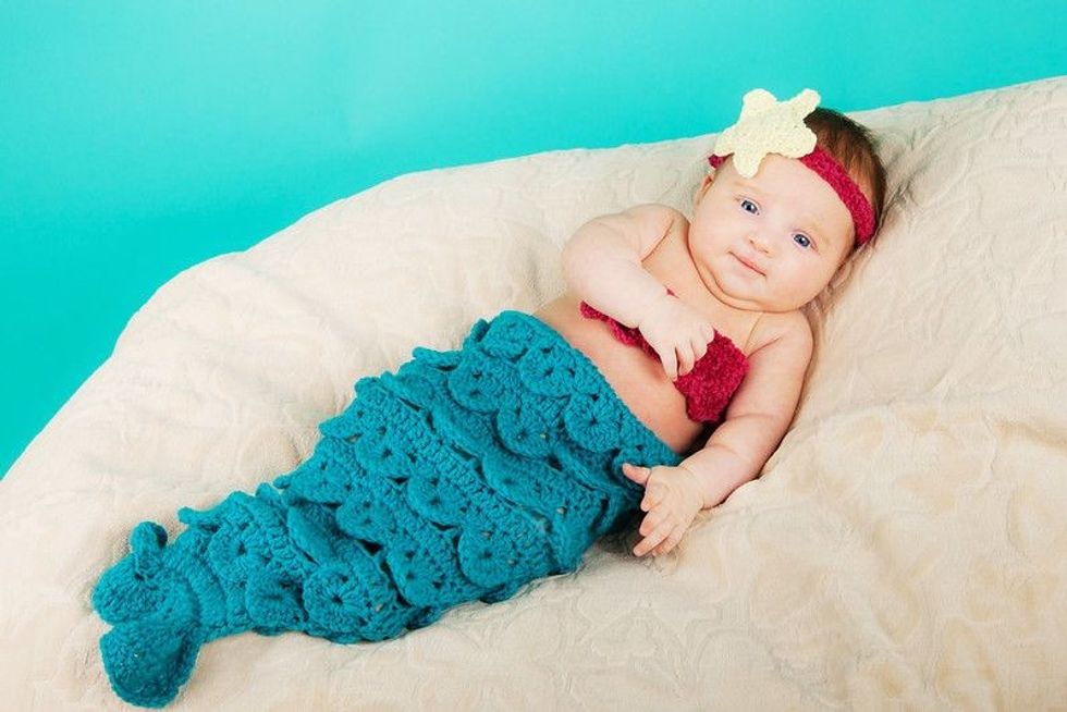 Cute newborn baby girl wearing a mermaid costume