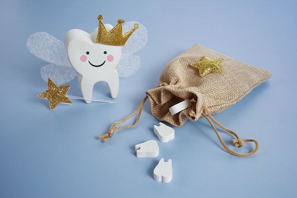 Cute tooth with wings, a crown and a magic wand and bag with teeth.