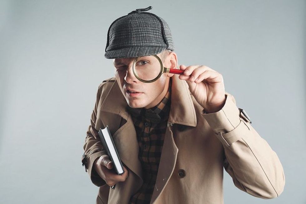 Detective with magnifying glass and note taking copy