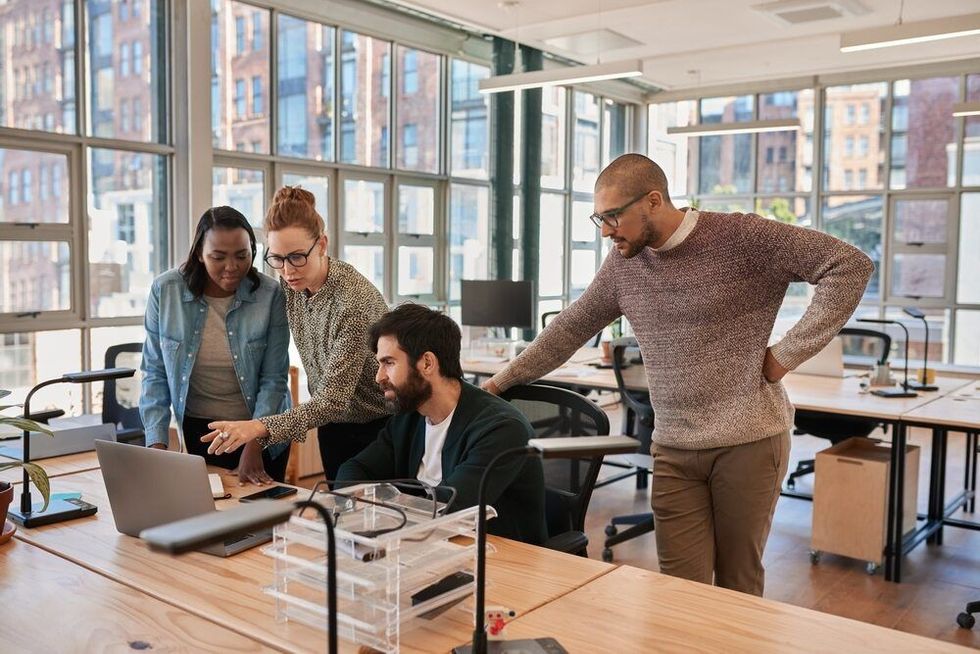 Diverse group of focused businesspeople working together on a laptop