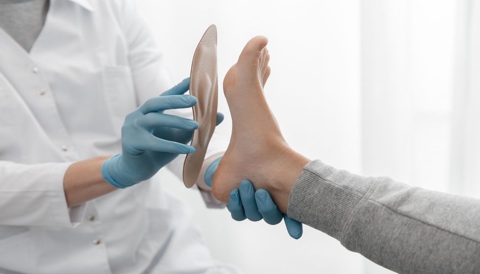 Doctor hands hold an orthopedic insole.