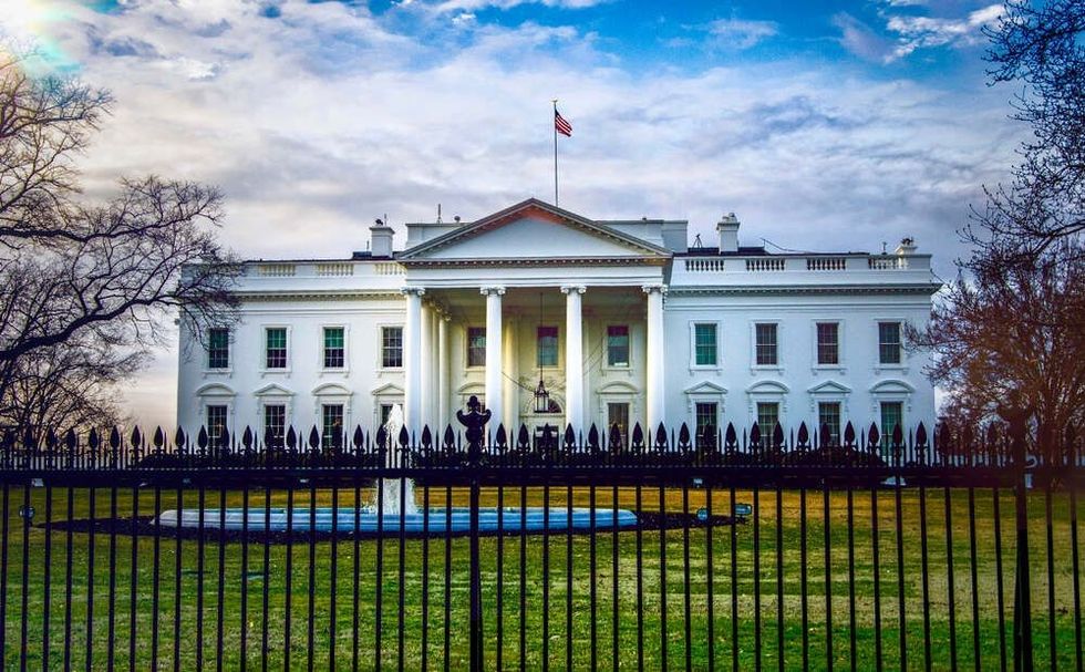 Early morning sun shining on the White House, presidential residence, in Washington DC with fountain in the foreground.