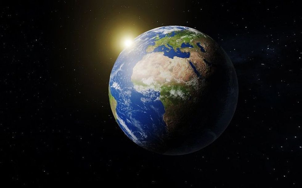 Earth in space with cosmos and the sun in the background