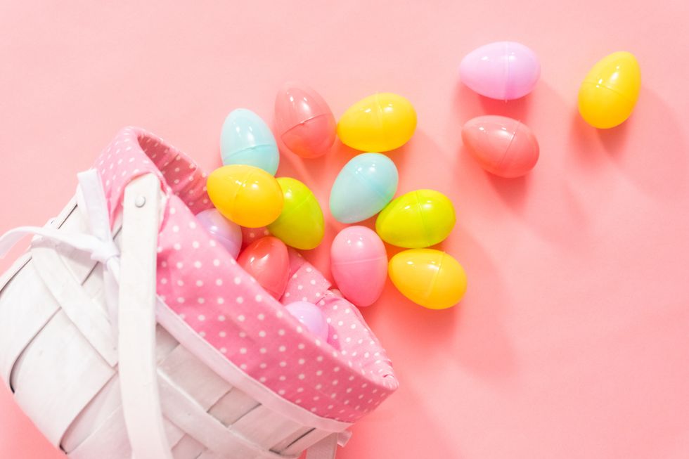 Easter basket with Easter eggs on a pink background.