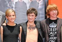Emma Watson, Daniel Radcliffe and Rupert Grint, smiling at an event.