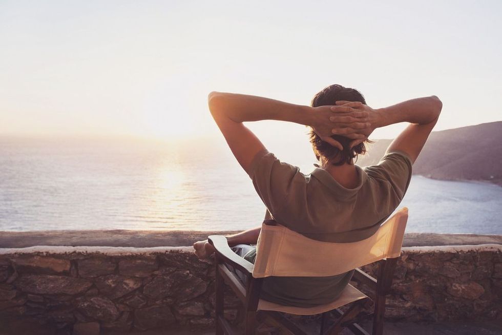 Enjoying life. Back side of young man looking at the sea, vacations lifestyle concept