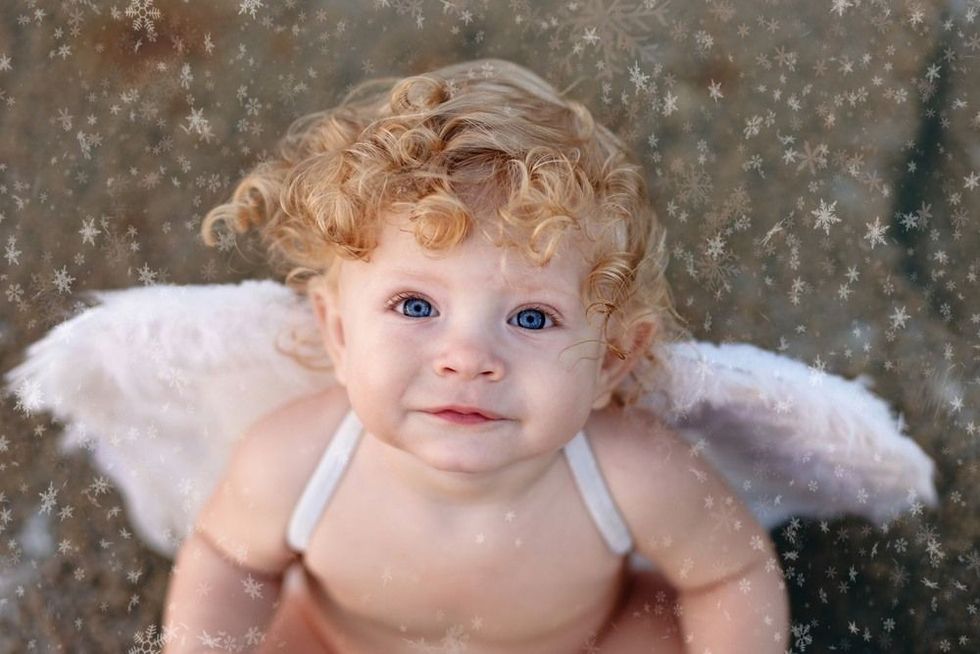 Face of beautiful little angel boy on a background of the snowflakes.