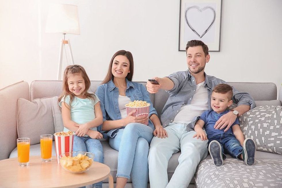Family watching TV together with popcorn