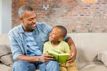 Father and son reading a book indoors