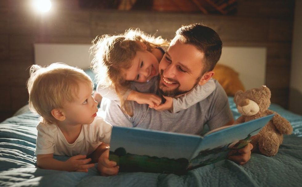 Father reads children a book before going to bed