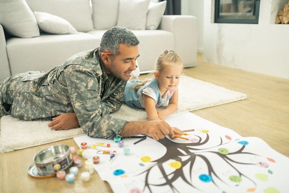 father with child making A Thumb Print Family Tree