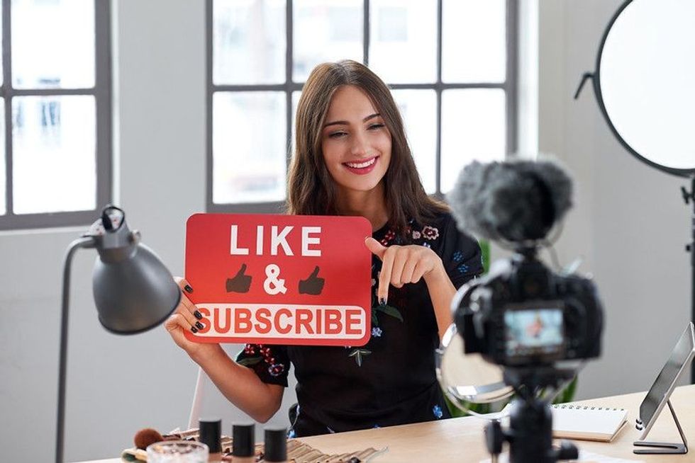 Female vlogger asking online audience to like and subscribe to her channel