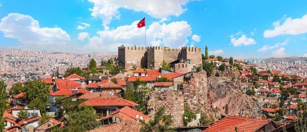 Flag of Turkey waving on the historical monument on a hill in Ankara.