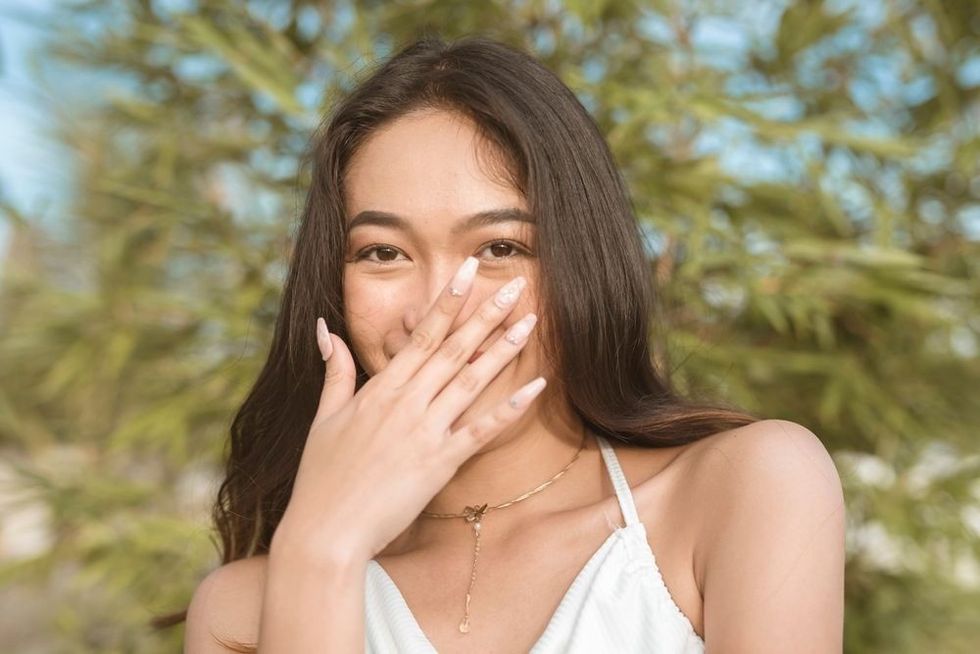 Flattered woman covering her mouth while blushing