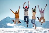 Friends jumping happily on a snowy mountain