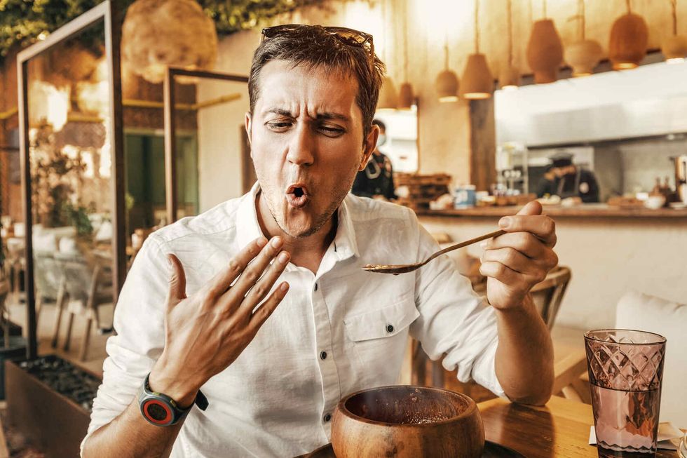 Funny man tries a spicy and hot dish.