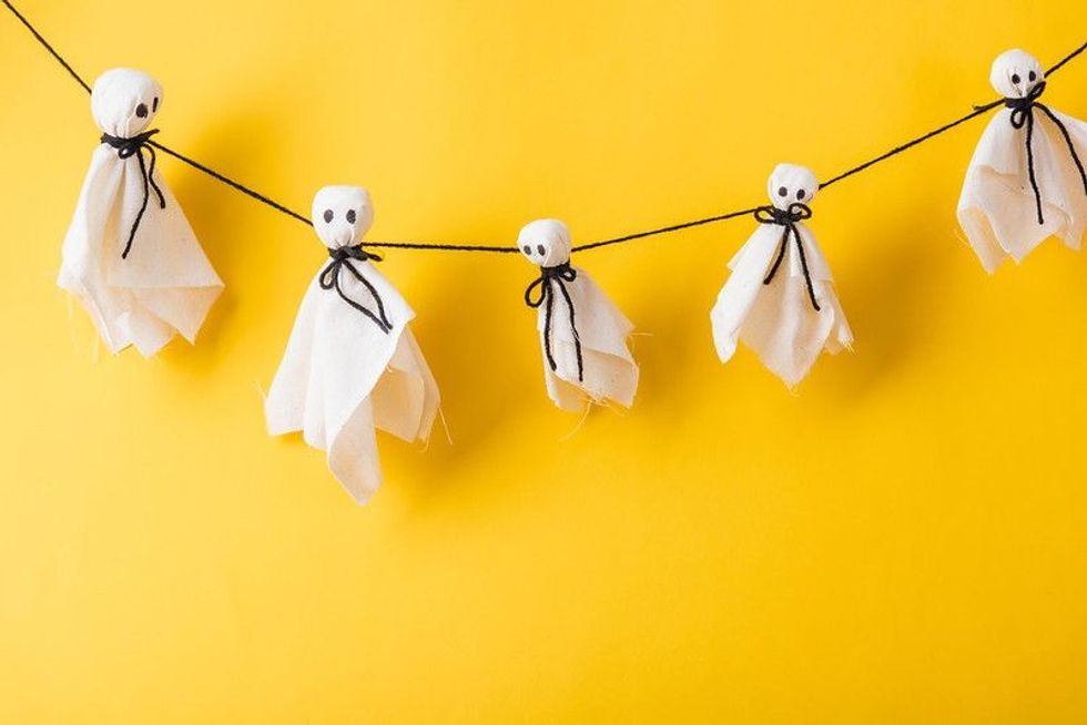 Ghost tied with thread on yellow wall