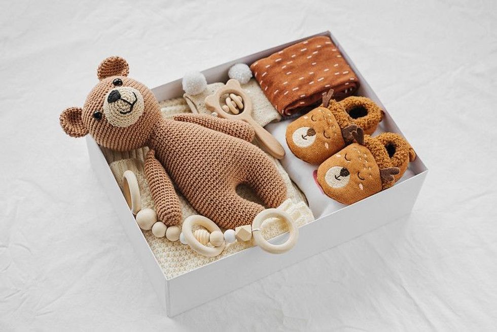 Gift box with knitted blanket, clothes, socks, shoes and toy