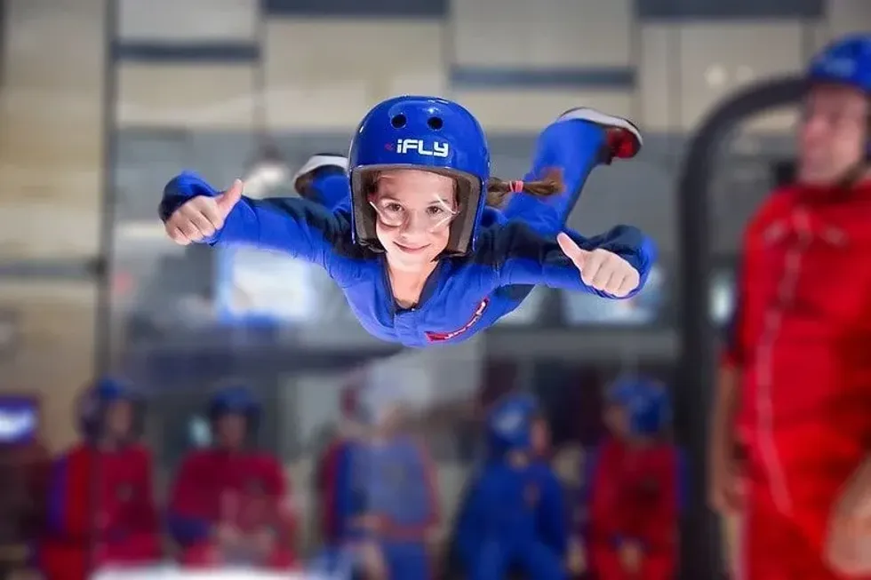 Girl giving thumbs up sign whilst doing indoor skydiving at iFly.