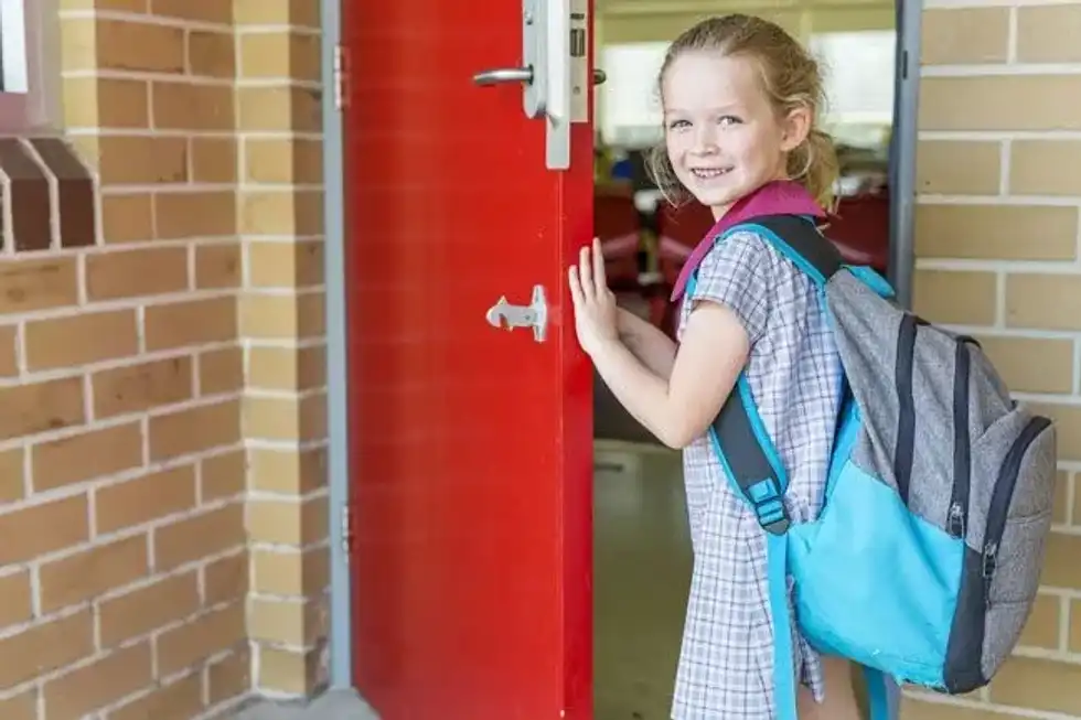 girl opening school door on first day at school