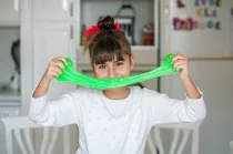 Girl playing with neon green slime.