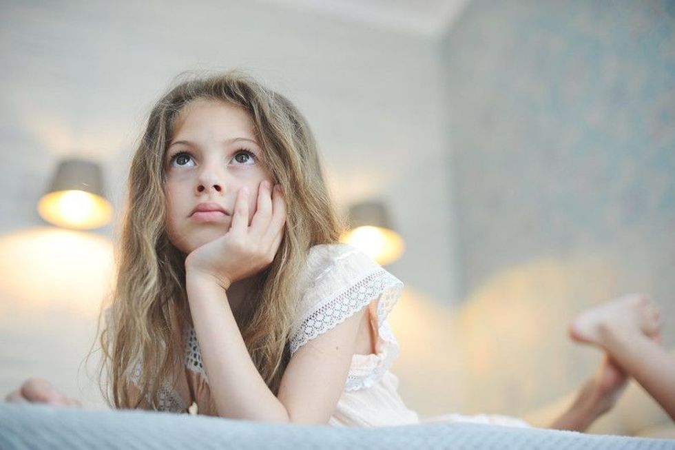 Girl thinking while lying on bed